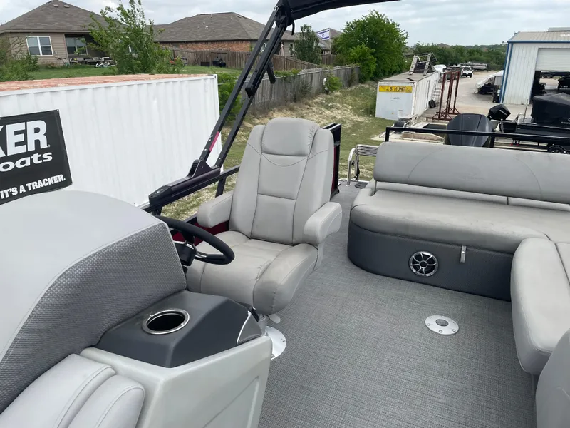 Slide: The Image of 2022 Regency 250 DL3 pontoon boat interior with gray seating and steering console. - 15