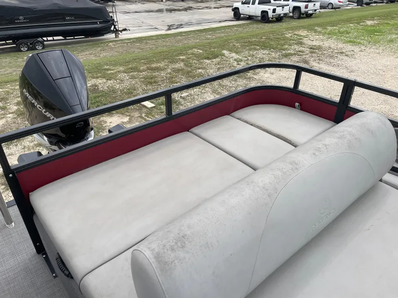 Slide: The Image of 2022 Regency 250 DL3 pontoon boat with spacious seating and outboard motor. - 16