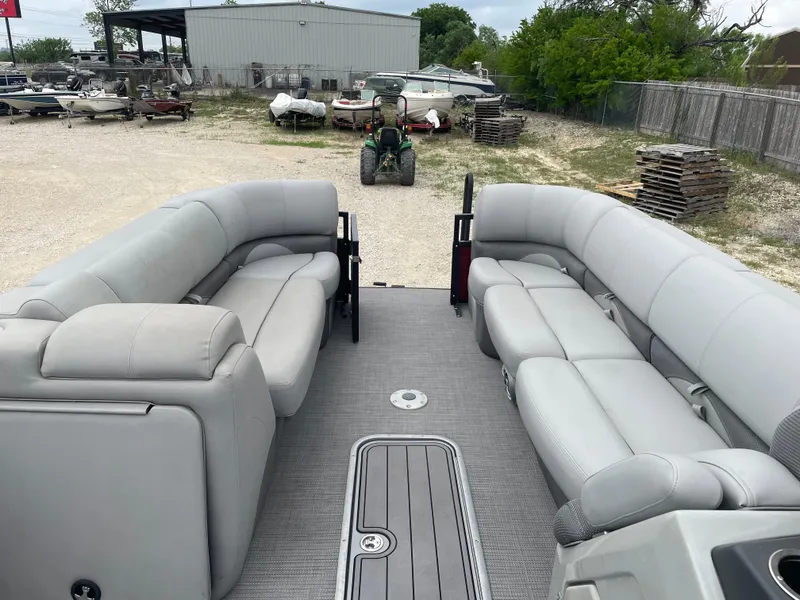 Slide: The Image of 2022 Regency 250 DL3 pontoon boat with spacious seating in a boatyard. - 20