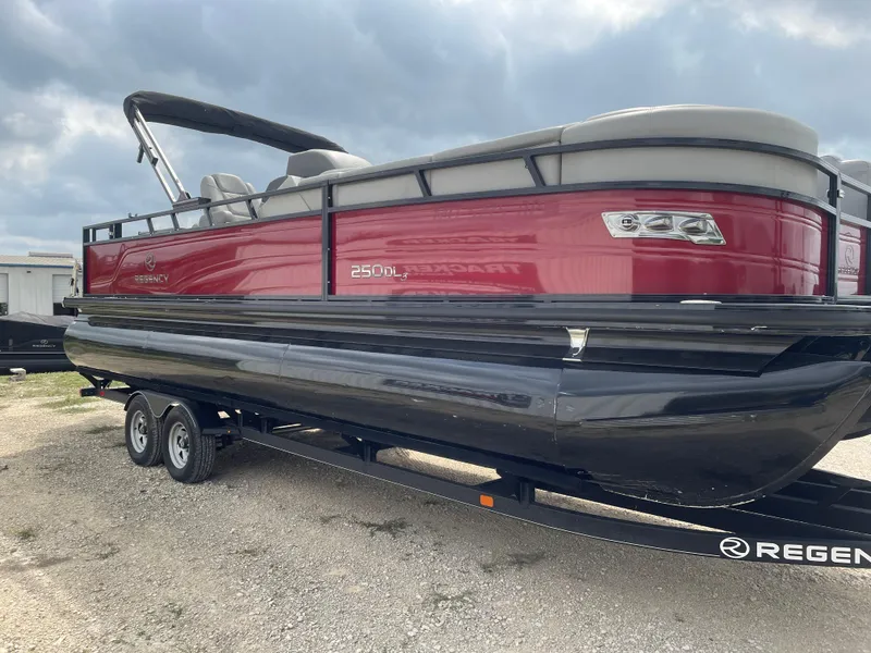 Slide: The Image of 2022 Regency 250 DL3 pontoon boat with red and black design on a trailer. - 6
