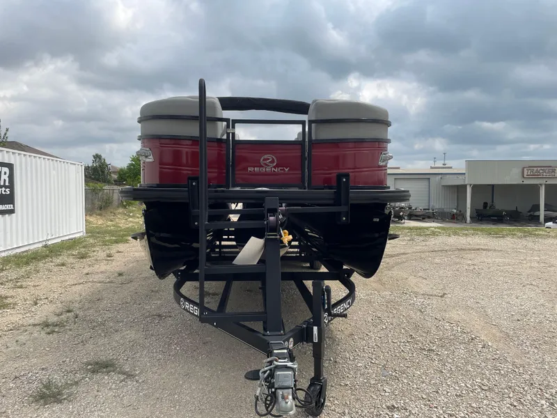 Slide: The Image of 2022 Regency 250 DL3 pontoon boat on trailer, parked outdoors under cloudy sky. - 8