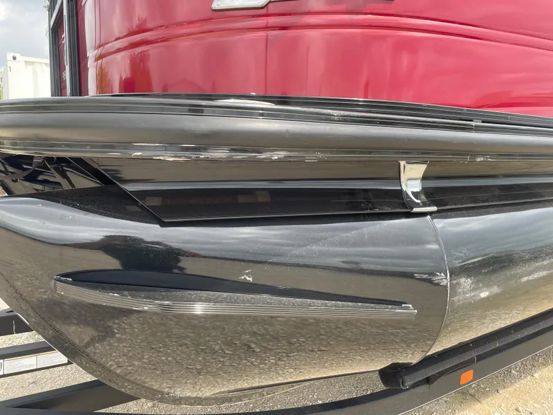 Slide: The Image of 2022 Regency 250 DL3 pontoon boat with sleek black and red exterior design. - 9