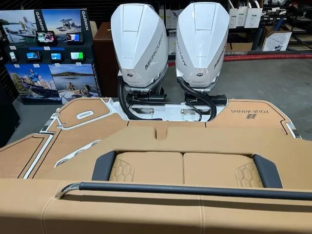 Slide: The Image of 2025 Four Winns H9 OB boat with dual Mercury outboard engines in showroom. - 12