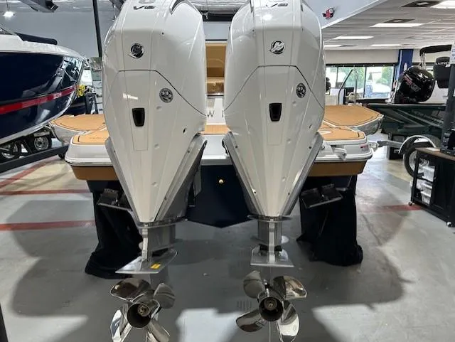 Slide: The Image of 2025 Four Winns H9 OB boat with dual outboard engines in showroom. - 3