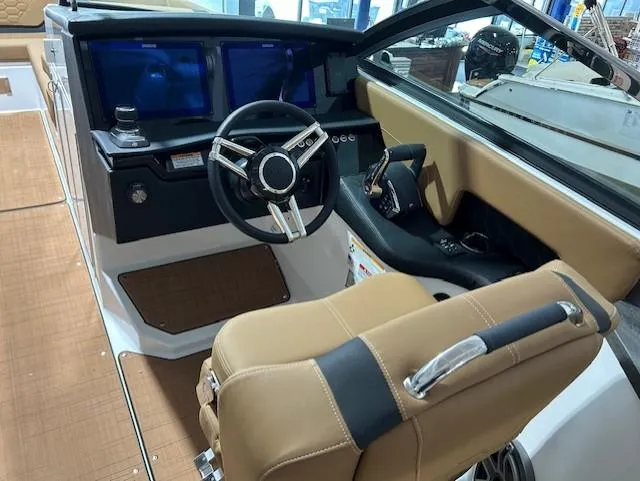 Slide: The Image of 2025 Four Winns H9 OB boat interior with modern dashboard and tan seating. - 7