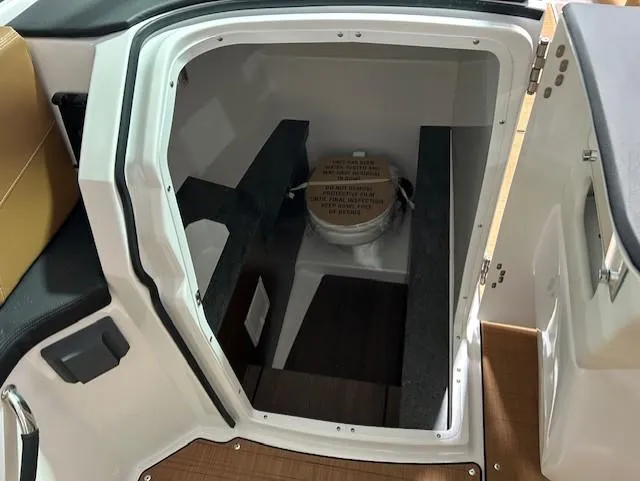 Slide: The Image of 2025 Four Winns H9 OB boat interior with compact restroom compartment. - 8