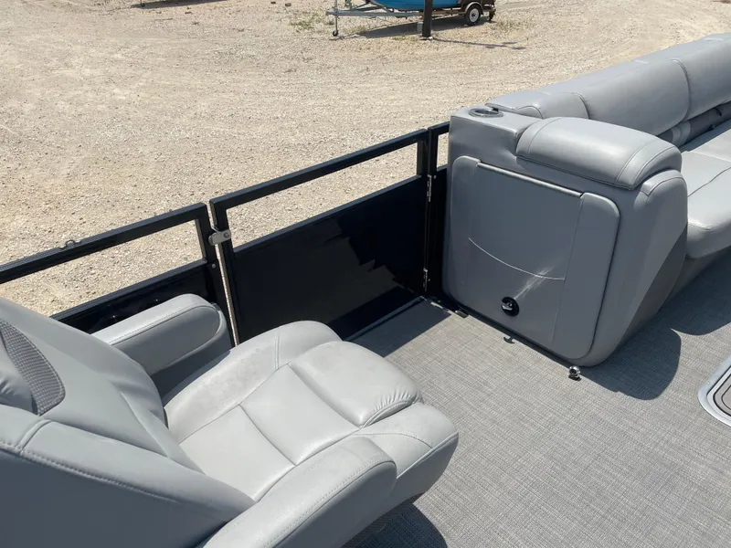 Slide: The Image of 2023 Regency 250 LE3 boat interior with gray seating and railing, on a sandy background. - 19