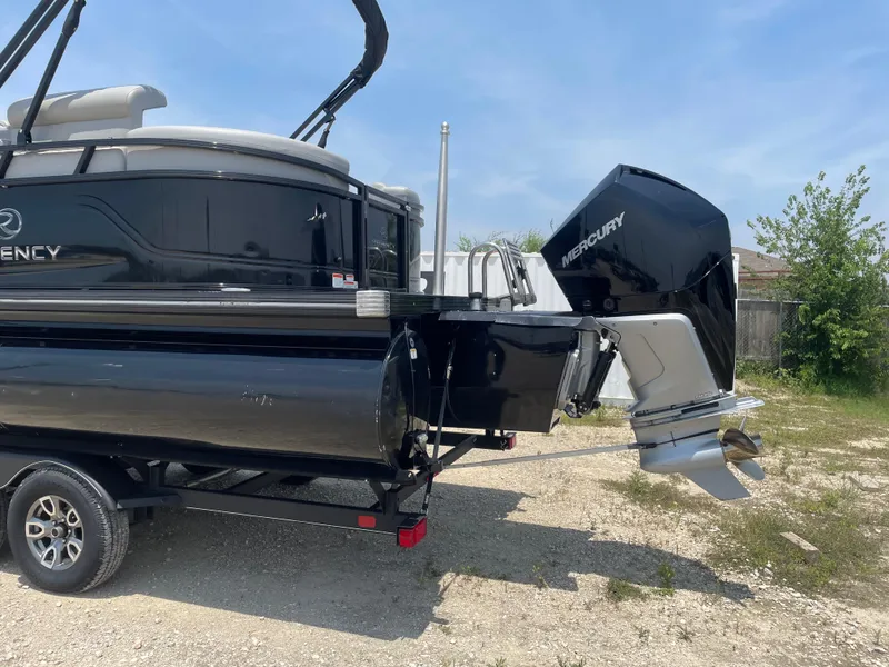 Slide: The Image of 2023 Regency 250 LE3 pontoon boat with Mercury outboard motor on trailer. - 2
