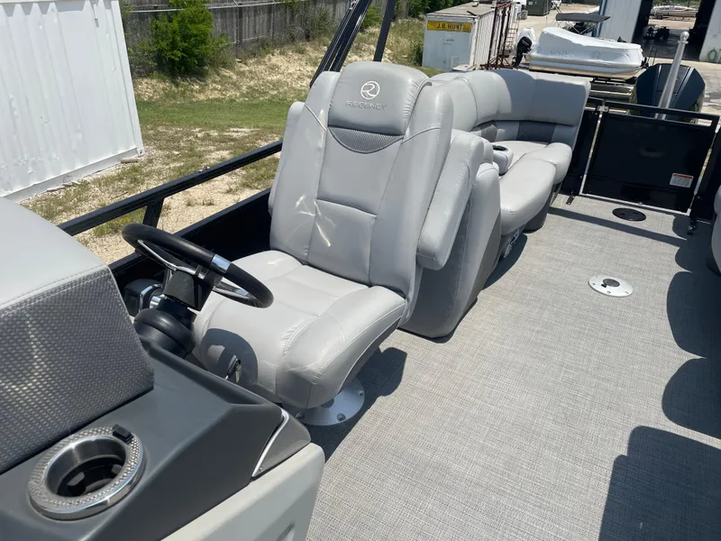 Slide: The Image of 2023 Regency 250 LE3 boat interior with gray seating and steering wheel. - 20