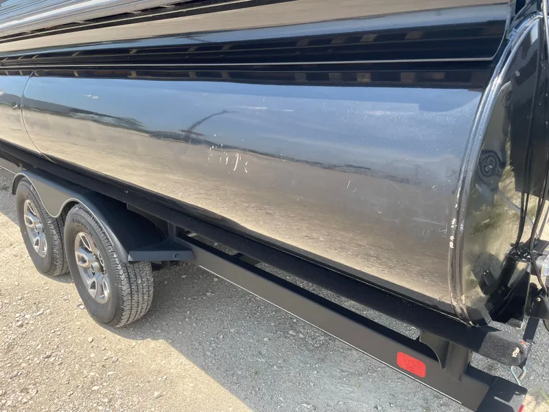 Slide: The Image of 2023 Regency 250 LE3 boat trailer with dual wheels on a gravel surface. - 9