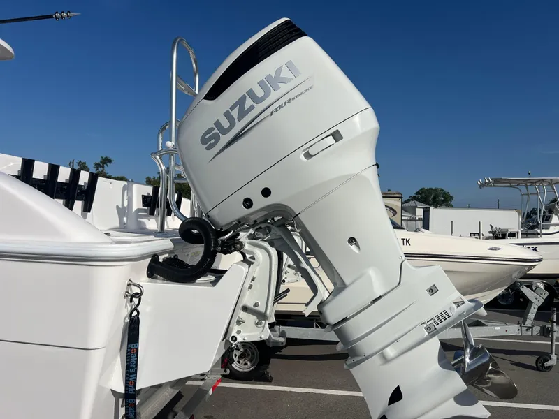 Slide: The Image of Twin Vee 280 GFX2 CC 2025 boat with Suzuki outboard motor, parked in a marina. - 16