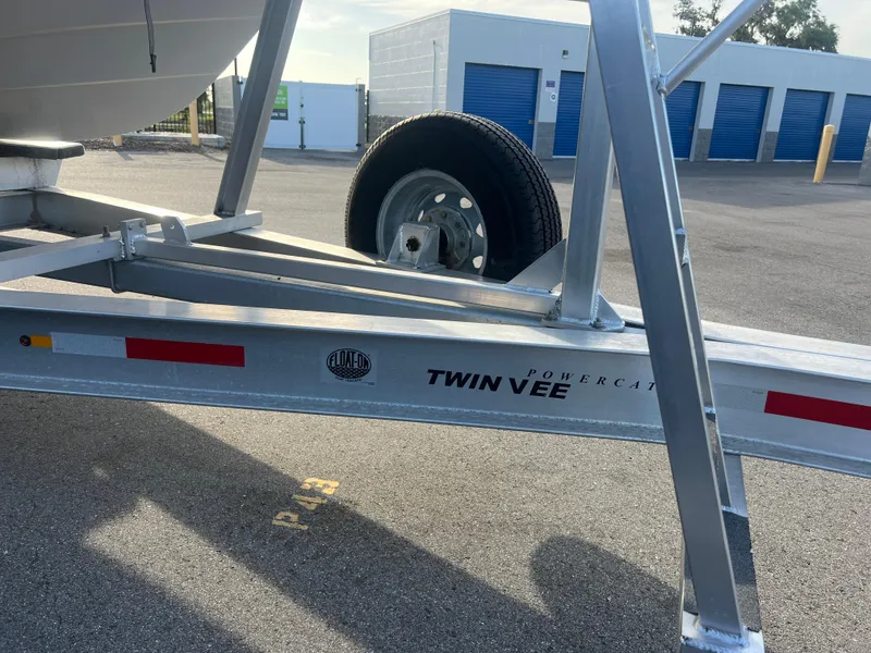 Slide: The Image of Trailer for 2025 Twin Vee 280 GFX2 CC boat, parked near storage units. - 17