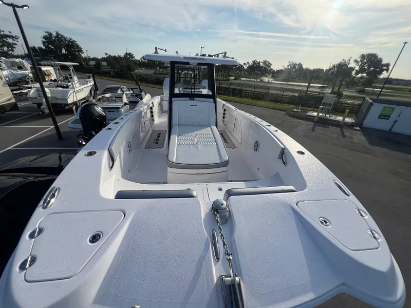 Slide: The Image of 2025 Twin Vee 280 GFX2 CC boat, sleek design, parked outdoors under a clear sky. - 3