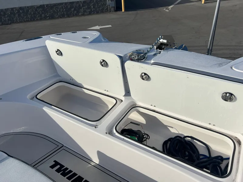 Slide: The Image of 2025 Twin Vee 280 GFX2 CC boat storage compartments with open lids and visible equipment. - 4