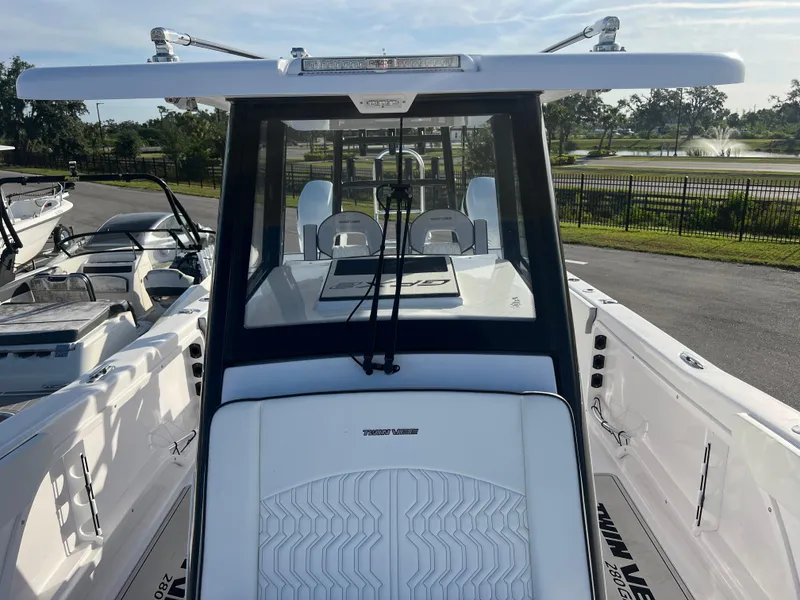 Slide: The Image of 2025 Twin Vee 280 GFX2 CC boat, sleek design, parked outdoors. - 5