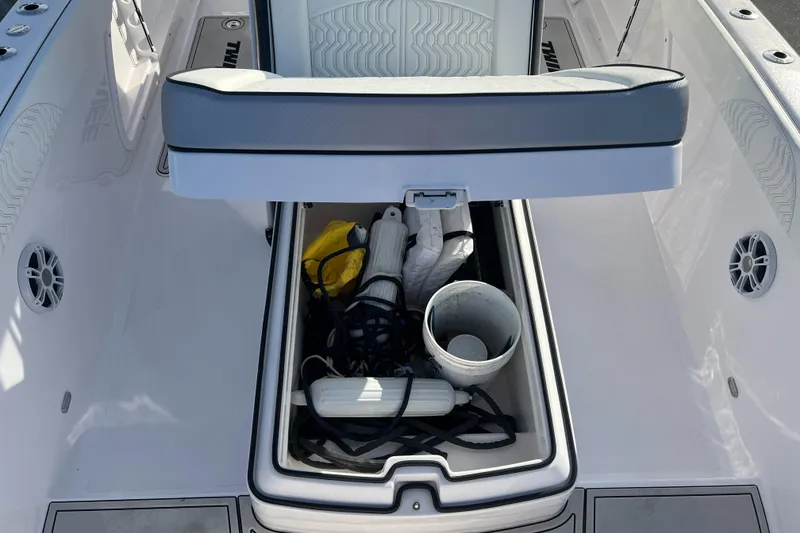 Slide: The Image of 2025 Twin Vee 280 GFX2 CC boat storage compartment with open lid and various items inside. - 6