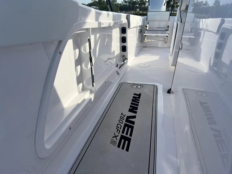 Slide: The Image of 2025 Twin Vee 280 GFX2 CC boat interior with sleek white design and branded flooring. - 8