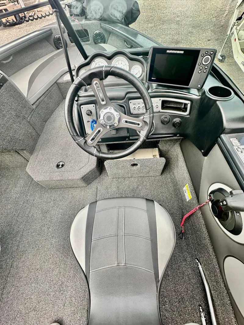 Slide: The Image of 2021 Lund 1875 Crossover XS boat interior with steering wheel and control panel. - 13