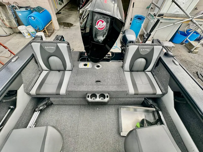 Slide: The Image of 2021 Lund 1875 Crossover XS boat interior with gray seating and Mercury outboard motor. - 15