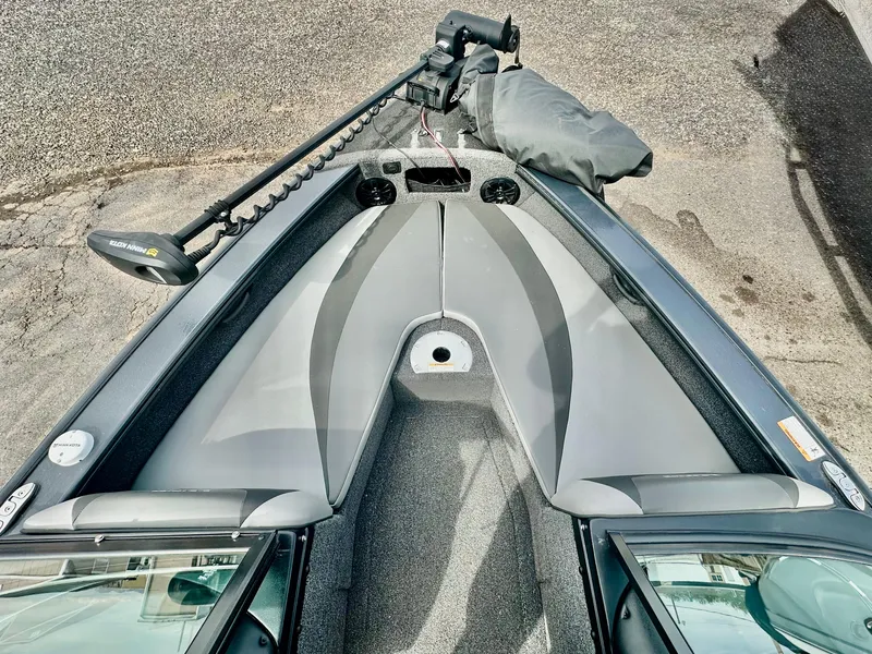 Slide: The Image of 2021 Lund 1875 Crossover XS boat interior with gray seating and trolling motor. - 17