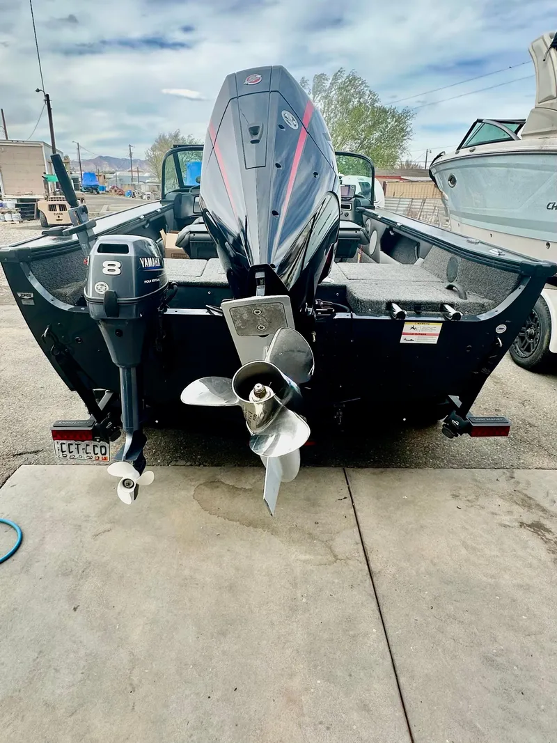 Slide: The Image of 2021 Lund 1875 Crossover XS boat with outboard motor, parked on concrete. - 4