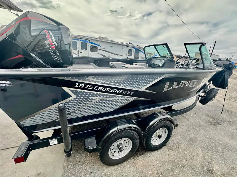 Slide: The Image of 2021 Lund 1875 Crossover XS boat on trailer, featuring sleek design and modern features. - 6