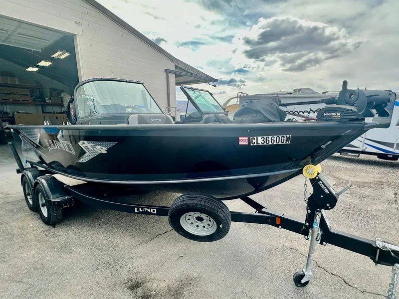 Slide: The Image of 2021 Lund 1875 Crossover XS boat on trailer, parked outdoors near a building. - 7
