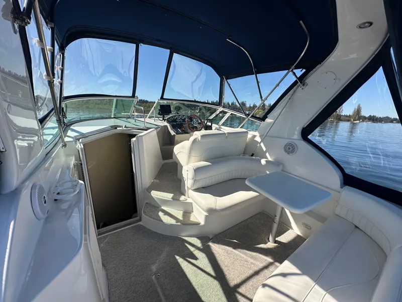Slide: The Image of 2004 Cruisers Express boat interior with white seating and blue canopy on a sunny day. - 10