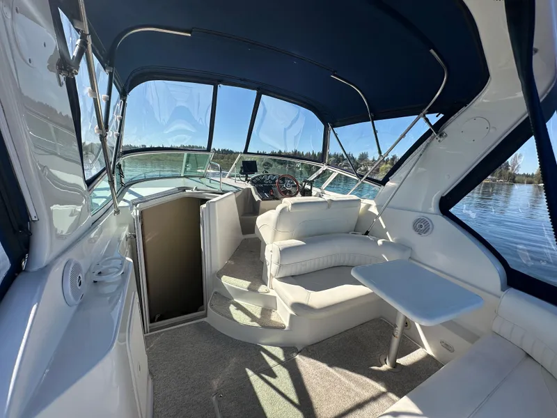 Slide: The Image of 2004 Cruisers Express boat interior with seating, table, and helm under a blue canopy. - 11