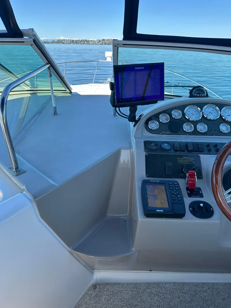 Slide: The Image of 2004 Cruisers Express boat helm with navigation equipment and gauges on a sunny day. - 12