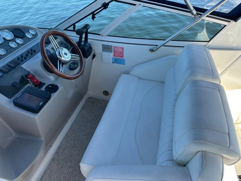 Slide: The Image of 2004 Cruisers Express boat interior with steering wheel and cushioned seating. - 14