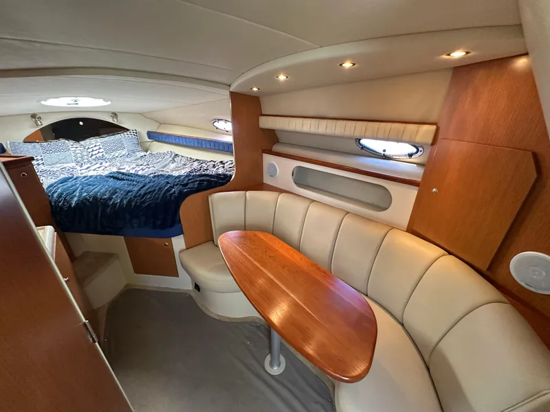 Slide: The Image of 2004 Cruisers Express yacht interior with cozy seating and elegant wood finishes. - 21