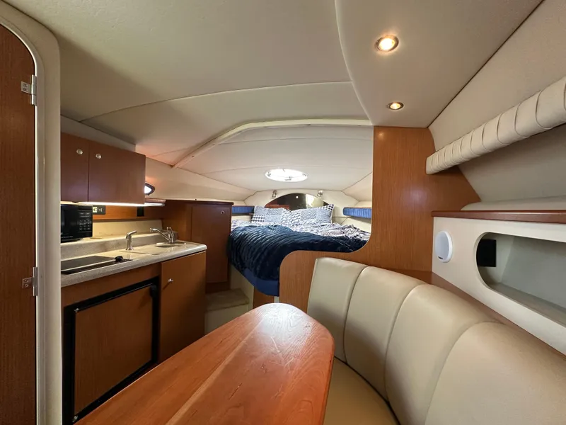 Slide: The Image of Interior of a 2004 Cruisers Express yacht with kitchen, seating, and bed. - 22