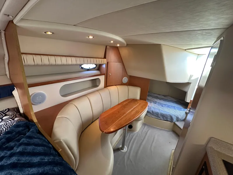 Slide: The Image of 2004 Cruisers Express yacht interior with cozy seating and sleeping area. - 26