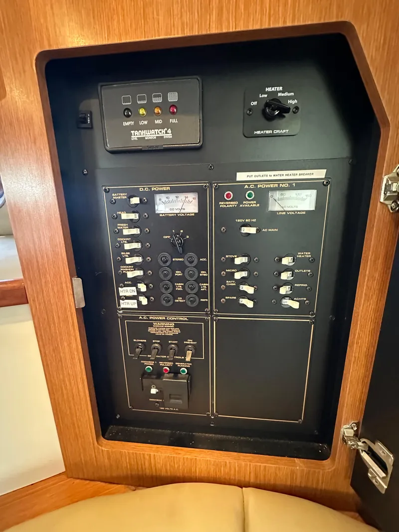 Slide: The Image of Electrical control panel inside a 2004 Cruisers Express boat, featuring various switches and indicators. - 28
