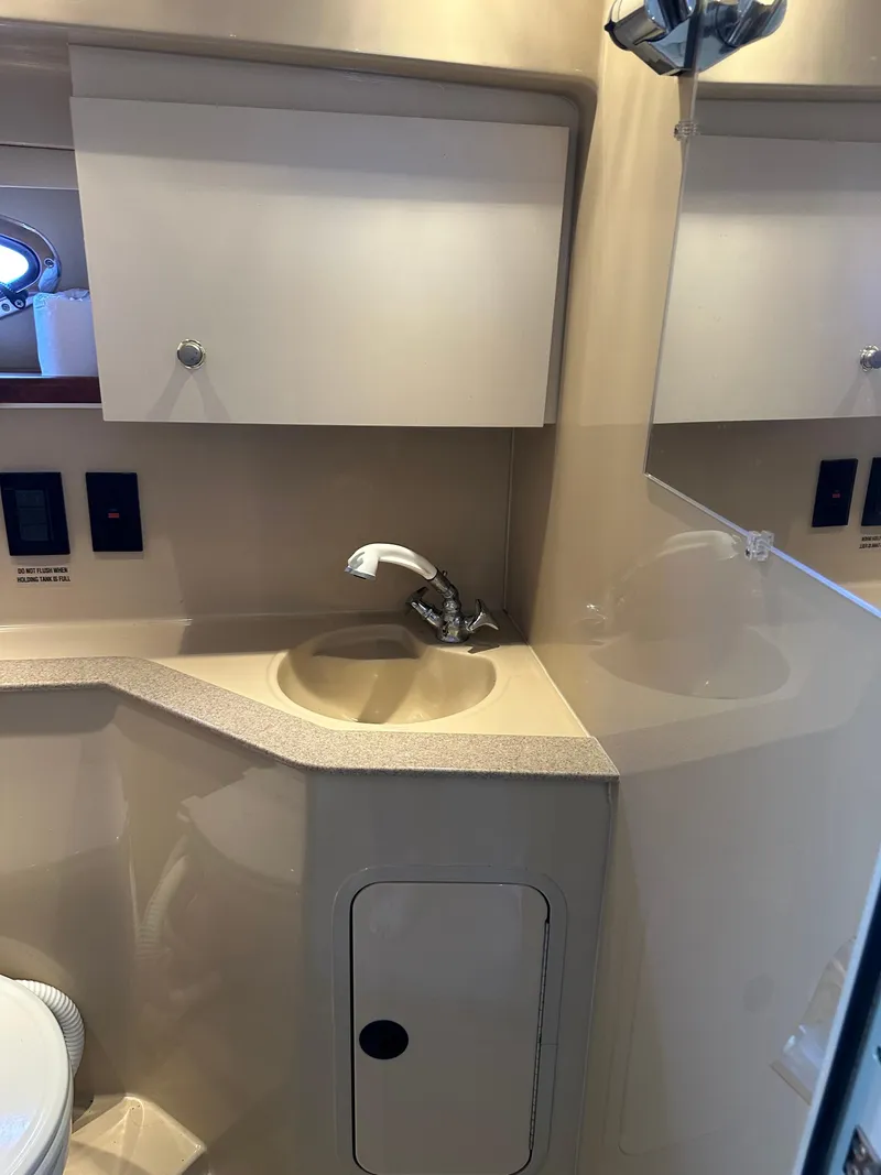 Slide: The Image of 2004 Cruisers Express yacht bathroom with sink, mirror, and storage cabinets. - 30