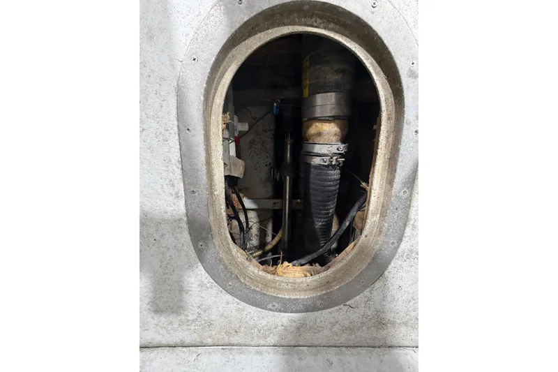 Slide: The Image of Engine compartment of a 1990 BEALS Lobster Boat, showing mechanical components and hoses. - 16