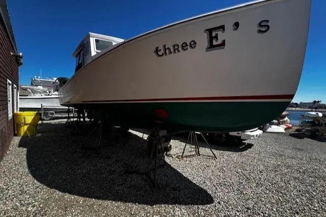 Slide: The Image of 1990 Downeast Beal Lobster Boat on gravel, side view. - 2