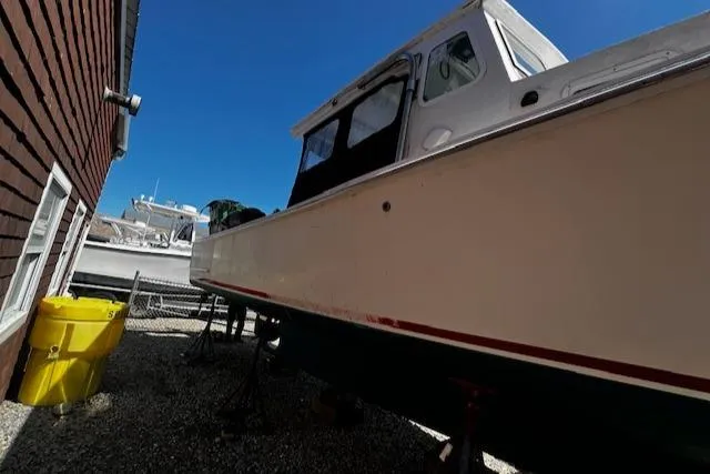 Slide: The Image of 1990 Downeast Beal Lobster Boat beside building. - 24