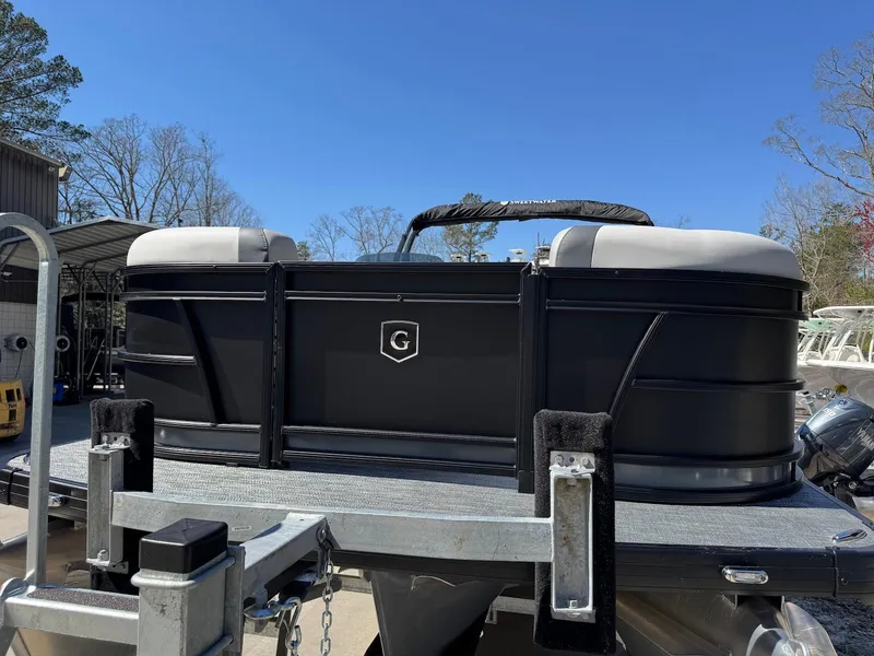 Slide: The Image of 2025 Godfrey Sweetwater 2286 SFLC pontoon boat on trailer, black exterior, sunny day. - 7