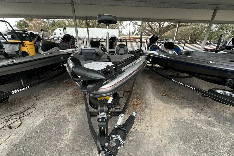 Slide: The Image of 2025 Ranger Z185 boat on trailer, parked under shelter, surrounded by other boats. - 122