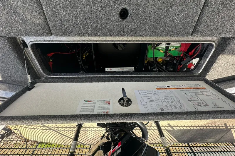 Slide: The Image of Open storage compartment of 2025 Ranger Z185 boat, showing wiring and battery setup. - 99