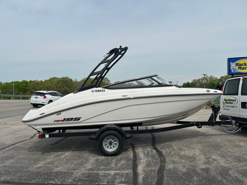 Slide: The Image of 2025 Yamaha AR195 boat on trailer, parked in a lot. - 3