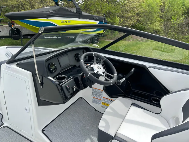 Slide: The Image of 2025 Yamaha Boats AR195 interior with sleek dashboard and steering wheel. - 6