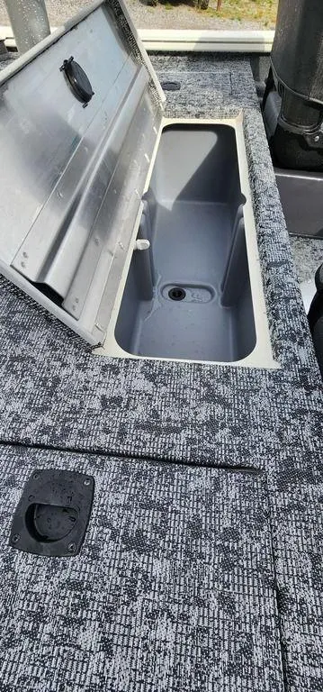 Slide: The Image of 2024 Tracker Pro Team 175 TF boat storage compartment with open lid, showcasing interior space. - 10