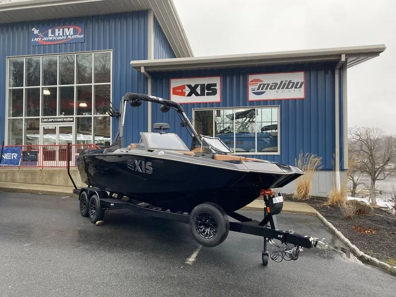 The Image of 2025 Axis A225 boat on trailer outside dealership, overcast day. - 1