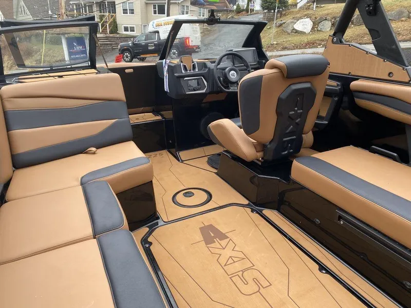 Slide: The Image of 2025 Axis A225 boat interior with tan and black seating, modern dashboard, and spacious layout. - 15