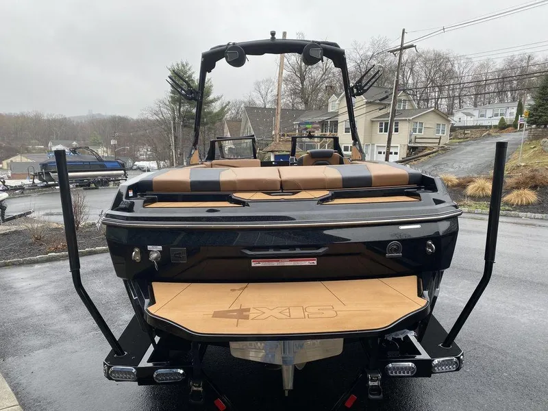 Slide: The Image of 2025 Axis A225 boat, rear view, parked on a wet driveway. - 4