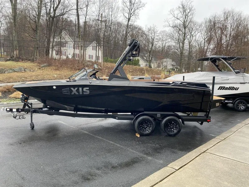 Slide: The Image of 2025 Axis A225 boat on trailer, parked outdoors on a rainy day. - 6