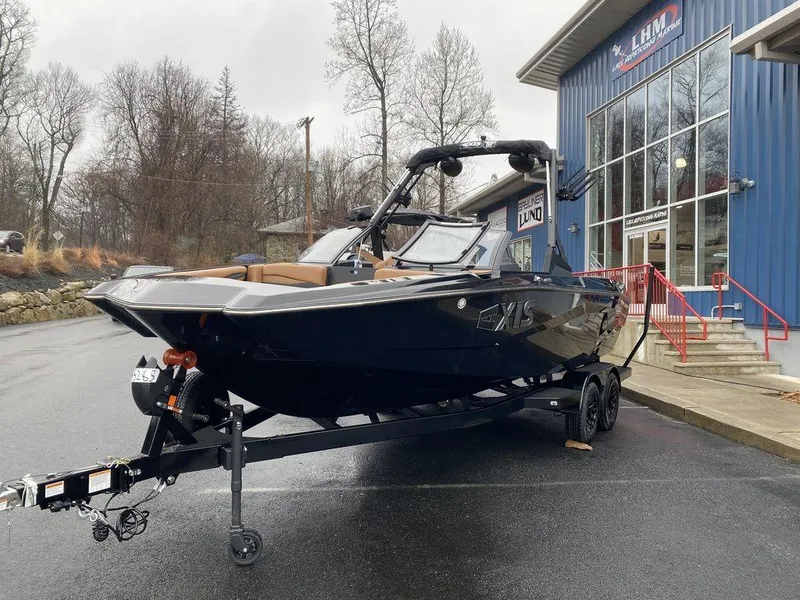 Slide: The Image of 2025 Axis A225 boat on trailer outside dealership, overcast day. - 7
